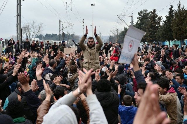 Migrants mass on the Greek-Macedonian borders shouting 'open the border' as they block train tracks on February 28, 2016. - LOUISA GOULIAMAKI/AFP/Getty