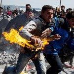 A man runs after he tried to put himself on fire during a protest at a makeshift camp at the Greek-Macedonian border near the village of Idomeni on March 22, 2016. Greece will not be able to start sending refugees back to Turkey from March 20, 2016, the government said, as the country struggles to implement a key deal aimed at easing Europe's migrant crisis. The numbers are daunting: officials said as of Saturday there were 47,500 migrants in Greece, including 8,200 on the islands and 10,500 massed at the Idomeni camp on the Macedonian border. / AFP / ANDREJ ISAKOVIC (Photo credit should read ANDREJ ISAKOVIC/AFP/Getty Images)