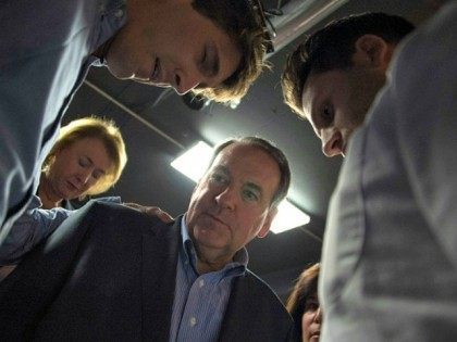 Presidential Candidate Mike Huckabee stands in a prayer circle with his supporters after s