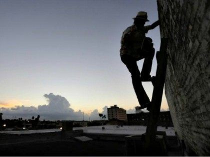 Man Climbing Border Wall AP PhotoEric Gay