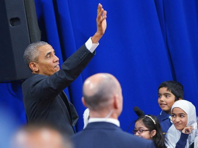 Barack Obama waves after greeting attendees in an overflow room at the Islamic Society of