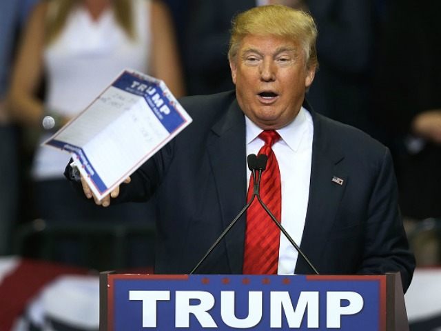 Republican presidential candidate Donald Trump tosses a paper into the crowd as he speaks
