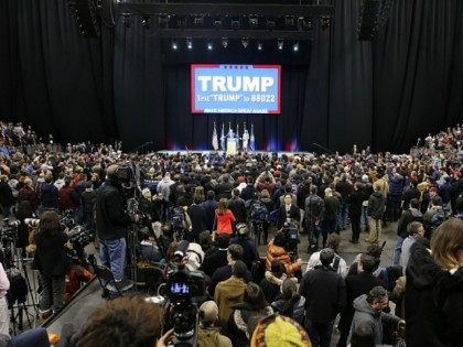 People listen as Republican presidential candidate Donald Trump speaks during a campaign r