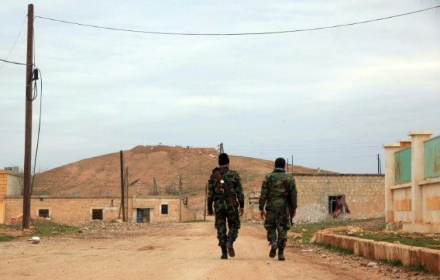 Syrian government forces patrol after taking control of the village of Kiffin, on the nort