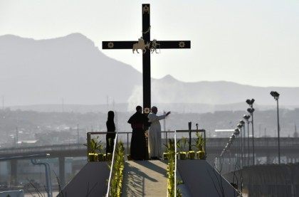 Pope Francis waves next to the US border before celebrating mass at the Ciudad Juarez fairgrounds in Mexico on February 17, 2016