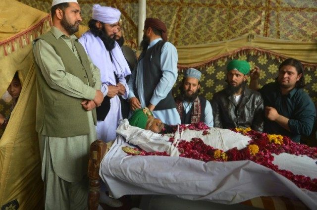 Relatives and supporters gather around the body of convicted murderer Mumtaz Qadri followi