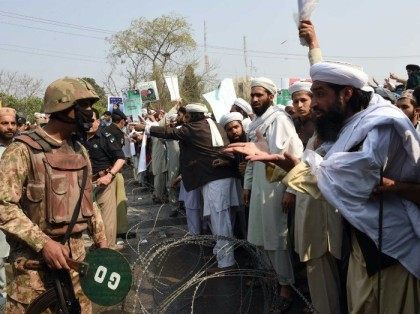 Pakistani supporters of convicted murderer Mumtaz Qadri argue with soldiers as they demons
