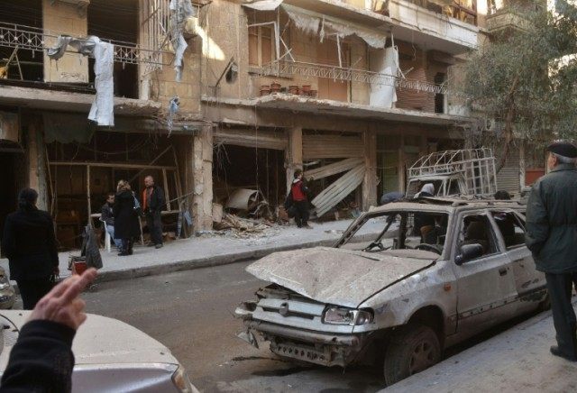 Syrian residents look at the damage following reported rebel shelling in Aleppo's governme