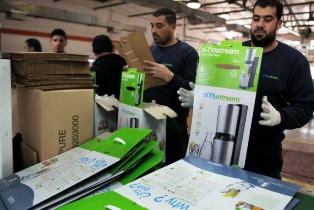 Palestinian workers prepare boxes to pack products at the Israeli SodaStream factory in th