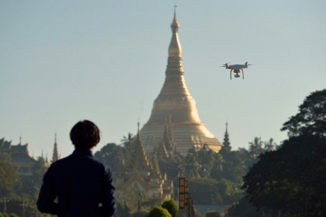 A drone enthusiast is seen piloting his remote controlled craft at a park in Yangon