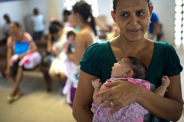A Brazilian mother holds her baby daughter who is suffering from microcephaly, a birth def