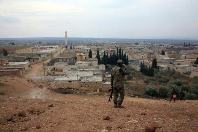 A member of the Syrian government forces patrols on the northern outskirts of the embattle