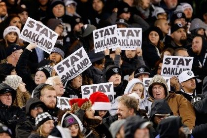 Oakland Raiders fans show 'Stay In Oakland' signs during the game against the San Diego Chargers on December 24, 2015 in Oakland, California