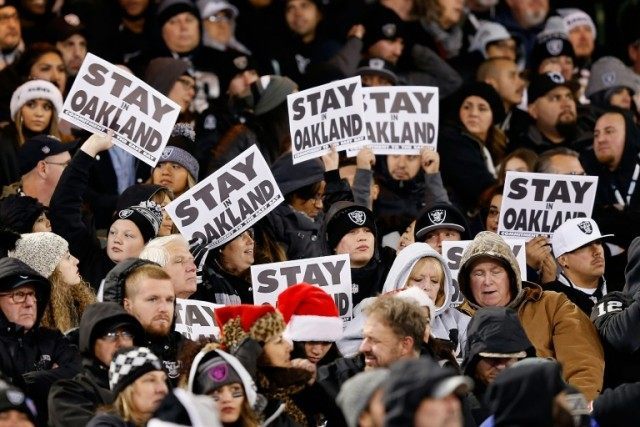 Oakland Raiders fans show 'Stay In Oakland' signs during the game against the San Diego Ch