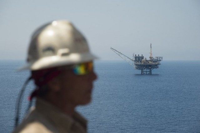 A worker from the Israeli gas-drill Tamar platform stands in front of the Mari-B platform