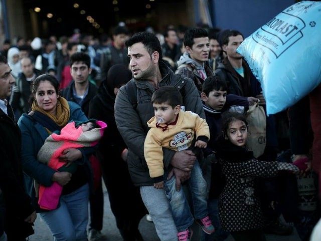 A migrant man carries a baby as refugees and migrants …
