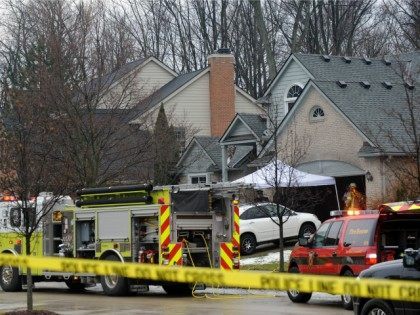 Police and fire officials investigate a house fire that killed five people at a home in No