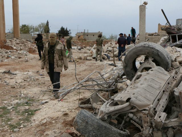 SYRIA, ALEPPO : Rebel fighters walk through the rubble following an alleged bombing by Isl