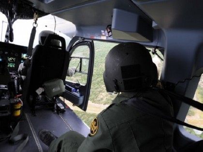 A Border Patrol agent points out an area of possible illegal activity to a National Guard