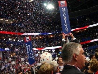 A person removes the sign for the Michigan delegation after Republican presidential candid