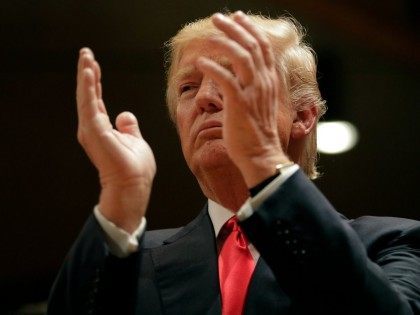 Republican presidential candidate Donald Trump applauds while visiting Saint Francis of Assisi Church, a caucus site, Monday, Feb. 1, 2016, in West Des Moines , Iowa. (