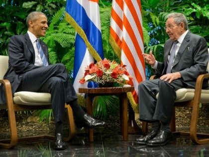 Cuban President Raul Castro, right, tries to lift up the arm of President Barack Obama at