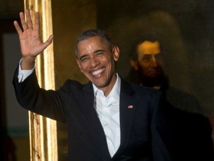 President Barack Obama waves to journalists next to a painting of President Abraham Lincol