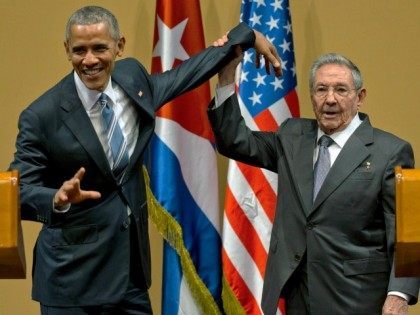 Cuban President Raul Castro, right, lifts up the arm of President Barack Obama at the conclusion of their joint news conference at the Palace of the Revolution, Monday, March 21, 2016, in Havana, Cuba.