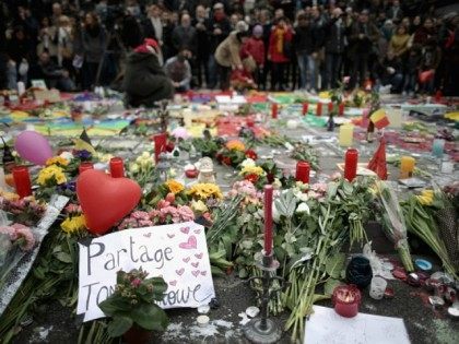 People observe a one minute silence at the Place De La Bourse in honour of the victims of yesterdays' terror attacks on March 23, 2016 in Brussels, Belgium.