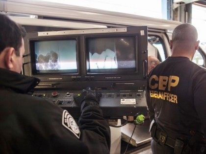 Two Office of Field Operations Officers man the mobile x-ray unit to scan fruit and vegeta