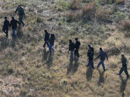 U.S. Border Patrol agents lead undocumented immigrants after capturing them near the U.S.-Mexico border on December 10, 2015 at La Grulla, Texas.