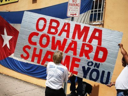 MIAMI, FL - JULY 20: Protestes hang a sign that reads, 'Obama Coward Shame on You', as they show their displeasure, in the Little Havana neighborhood, with the normalization of the Cuban/United States relationship as the Cuban Embassy opens after a 54 year absence in Washington, DC on July 20, …