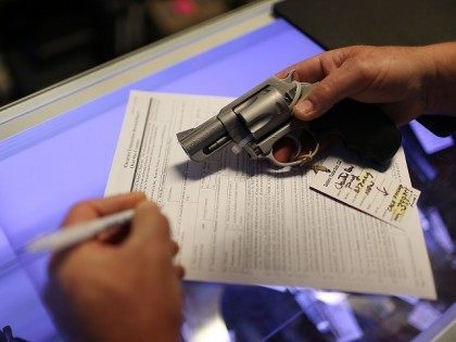 Mark O'Connor fills out his Federal background check paperwork as he purchases a handgun a