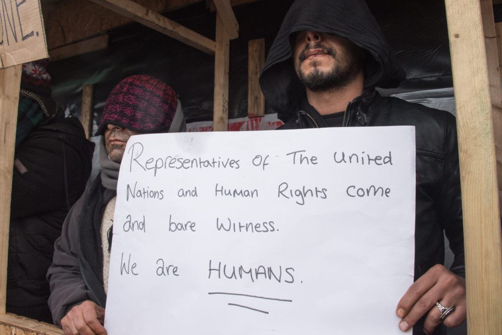 Iranian migrants who sew their lips to protest against the dismantling of the southern half of the so-called "Jungle" migrant camp, stage a protest in the French northern port city of Calais, on March 3, 2016. Demolition workers razed makeshift shelters at the so-called Jungle migrant camp on the outskirts of Calais for a fourth day running on March 3, under the close watch of dozens of police officers equipped with water cannon. / AFP / DENIS CHARLET (Photo credit should read DENIS CHARLET/AFP/Getty Images)