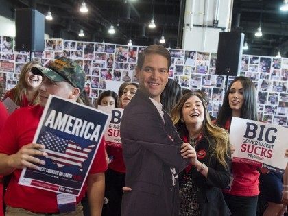 Grace Jackson (R) with Turning Point USA dances with a cutout of US Republican Presidentia
