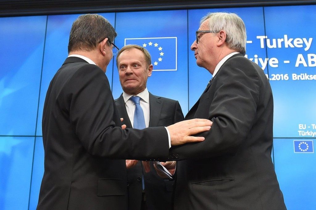 Turkey's Prime Minister Ahmet Davutoglu (L), European Council President Donald Tusk (C) and European Commission President Jean-Claude Juncker speak during a press conference at the end of an EU leaders summit with Turkey centered on the the migrants crisis, at the European Council, in Brussels on March 8, 2016. European Union leaders will on March 7 back closing down the Balkans route used by most migrants to reach Europe, diplomats said, after at least 25 more people drowned trying to cross the Aegean Sea en route to Greece. The declaration drafted by EU ambassadors on March 6 will be announced at a summit in Brussels on March 7, set to also be attended by Turkish Prime Minister Ahmet Davutoglu. / AFP / EMMANUEL DUNAND (Photo credit should read EMMANUEL DUNAND/AFP/Getty Images)