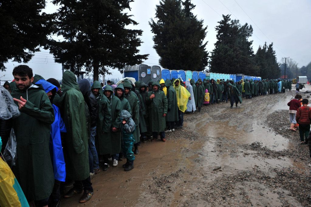 Migrants and refugees wait for food at the Greek-Macedonian border near the Greek village of Idomeni on March 9, 2016, where thousands of refugees and migrants are trapped by the Balkan border blockade. The Balkan trail from Greece to northern Europe used by floods of migrants was blocked on March 9 after a string of nations slammed shut their borders, hiking pressure on the EU and Turkey to nail down a "game-changing" grand bargain. / AFP / SAKIS MITROLIDIS (Photo credit should read SAKIS MITROLIDIS/AFP/Getty Images)