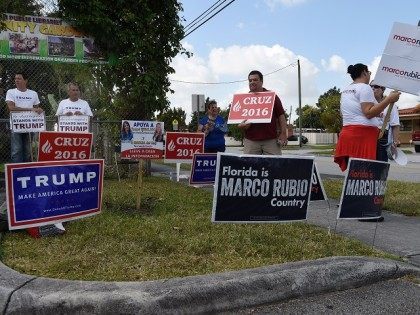 Supporters hold signs for Republican candidates in front of polling precinct for the Florida Primary on March 15, 2016 in Miami, Florida. Voters began going to the polls Tuesday in five make-or-break presidential nominating contests, with Republican Donald Trump and Democrat Hillary Clinton seeking to tighten their grip as their …