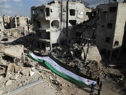 Residents and activists hold a giant a pre-Baath Syrian flag, now used by the Syrian oppos