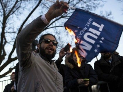 protester burns a flag outside of the University of Illinois at Chicago Pavilion where Rep