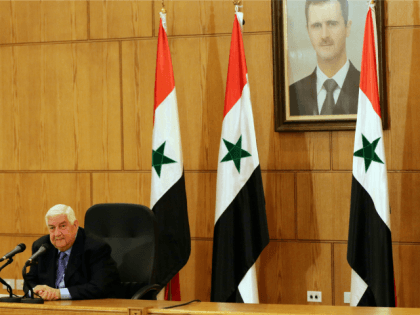 Syrian Foreign Minister Walid Muallem speaks during a press conference in front of a portrait of Syrian President Bashar al-Assad (R) on March 12, 2016 in the capital Damascus.