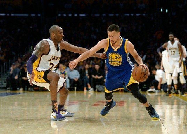 Stephen Curry (R) of the Golden State Warriors drives against Kobe Bryant of the Los Angel