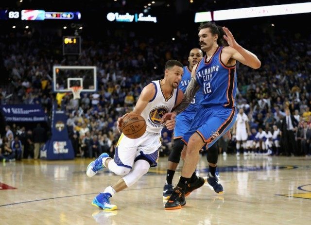 Stephen Curry of the Golden State Warriors drives on Steven Adams of the Oklahoma City Thu