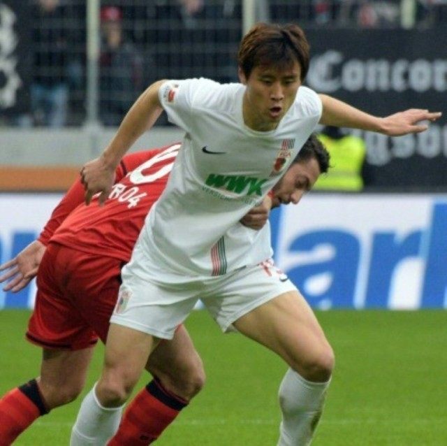 FC Augsburg's Koo Ja-Cheol and Leverkusen's Tin Jedvaj vie for the ball on March 5, 2016 i