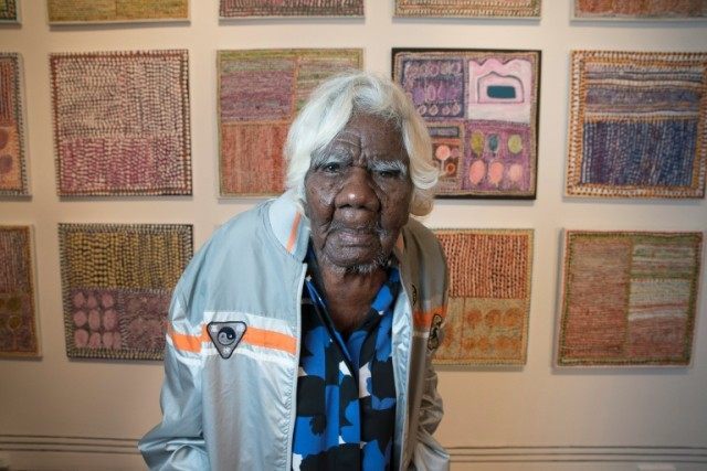 Aboriginal artist Loongkoonan stands in front of some of her artworks at the Art Gallery o
