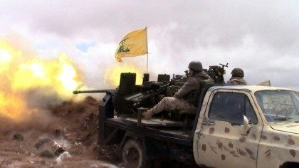 A Hezbollah fighter fires towards Syrian rebel areas on the Syrian side of the Qalamun hil