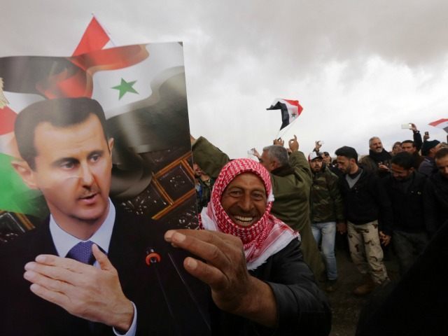Syrian volunteers and their relatives wave the national flag and portraits of President Ba