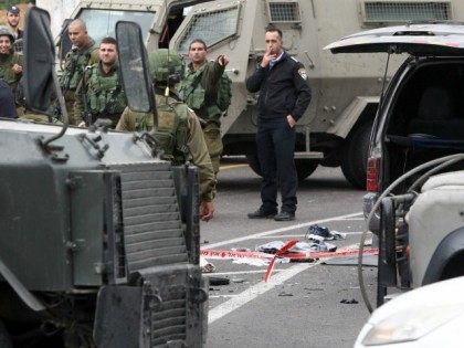 Israeli security forces stand guard at the scene where three Palestinians carried out two