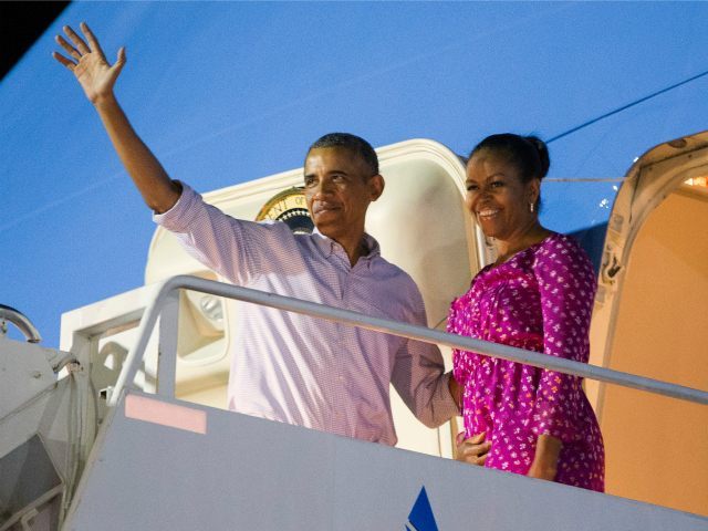 President Barack Obama, left, and first lady Michelle Obama wave as they board Air Force O