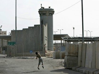 A Palestinian boy throws stones towards an Israeli army watchtower during clashes between Palestinian stone-throwers and Israeli soldiers at the Qalandia checkpoint near the West Bank city of Ramallah on October 16, 2009. Israel slammed the adoption of an 'unjust' UN report on the Gaza war on October 16, warning …
